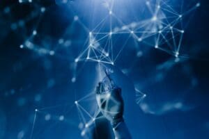 Free A robotic hand reaching into a digital network on a blue background, symbolizing AI technology. Stock Photo