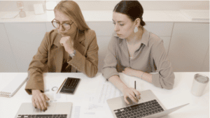 two women with laptops