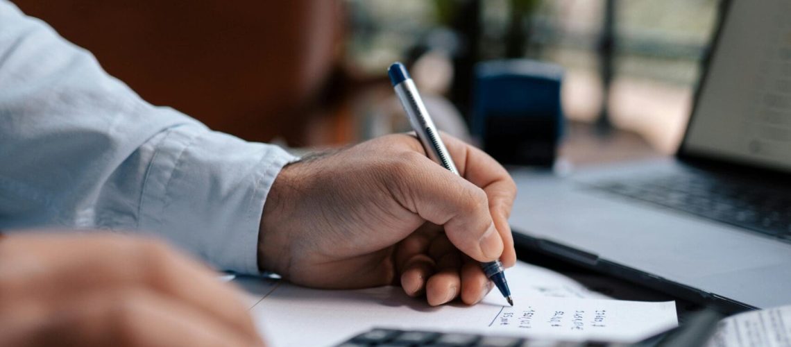 Invest-Smart-Grow-Fast-Your-Small-Business-Guide-to-IT-Expense-Planning-scaled.jpg Free A person calculating finances with a calculator and pen on a desk indoors. Stock Photo