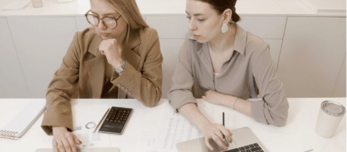 two women with laptops