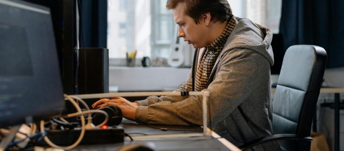 Free A concentrated professional working at a computer in a modern office setting. Stock Photo